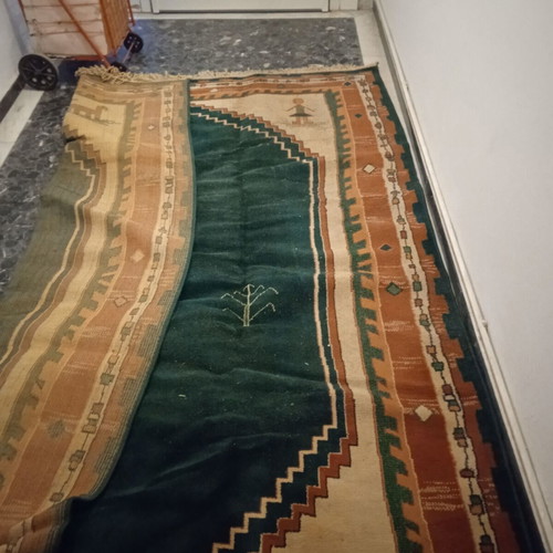Turquoise machine-made rug used with animal and human designs