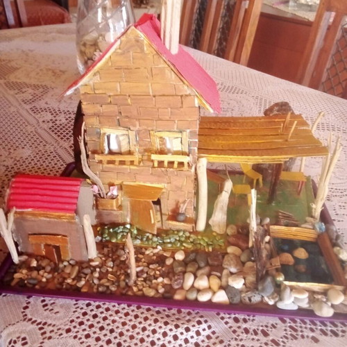 Handmade decorative house with cardboard, pebbles and driftwood, new