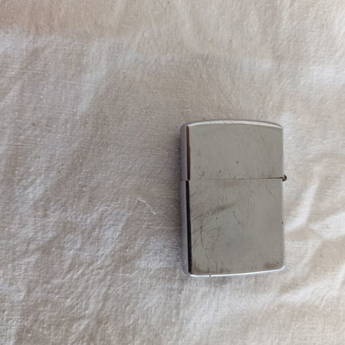 Windproof lighter with embossed metal emblem used