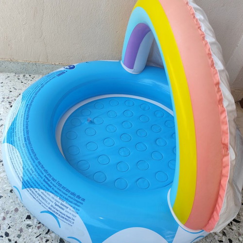 Blue children's pool with canopy used, rainbow design