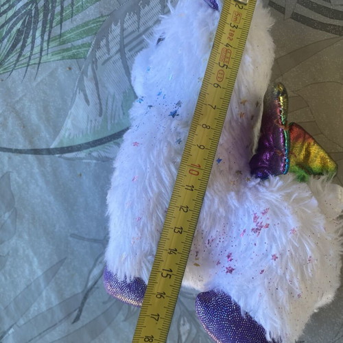 Unicorn plush toy with colorful shiny wings and metallic purple details