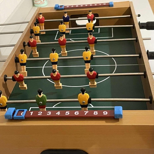 Children's foosball table used without balls and missing one handle