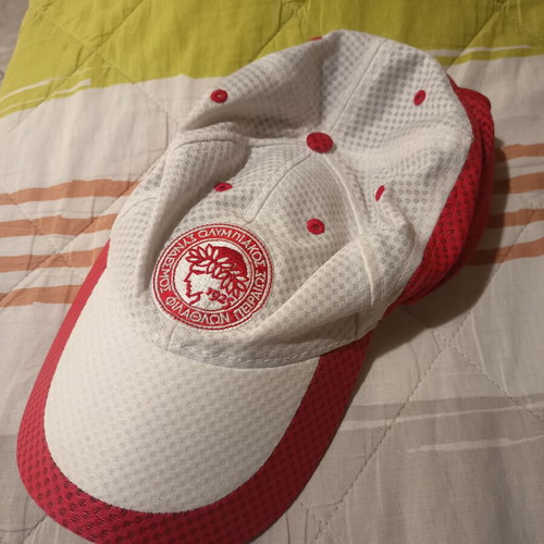 Real Madrid and Olympiakos accessories used with flag, scarf, and cap