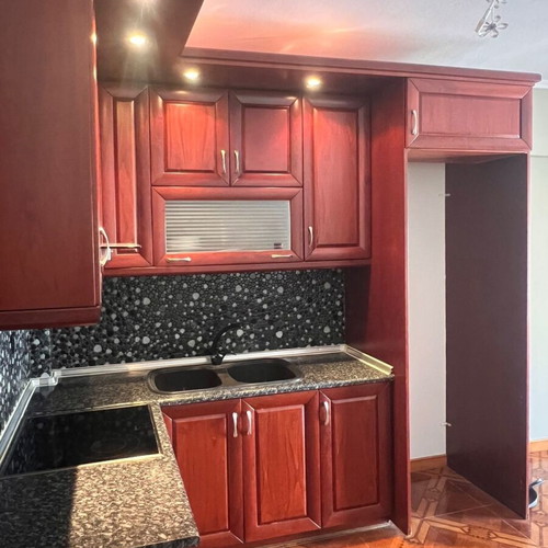 Corner kitchen made of solid cherry wood with extractor hood used