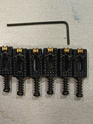 Set of roller saddles for electric guitar bridge, black and brass