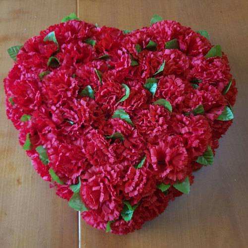 Heart made of artificial red flowers like new