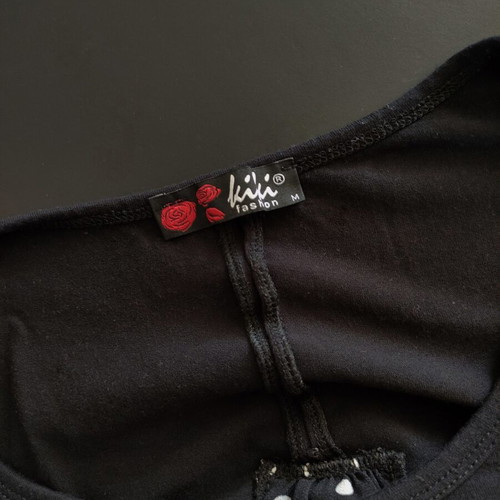 Women's black T-shirt with polka dot chiffon open back and button detail