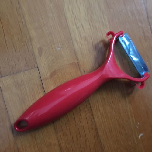 Red peeler new with thick handle made of durable plastic