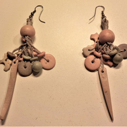 Long handmade earrings made of wood and cord in pastel colors