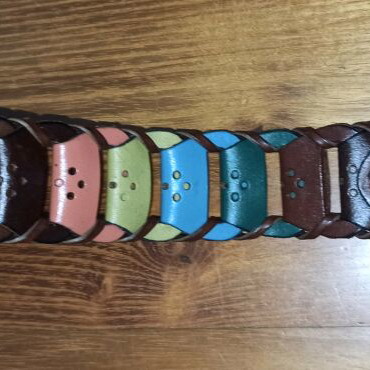 Colorful woven belt in warm shades made of faux leather, like new
