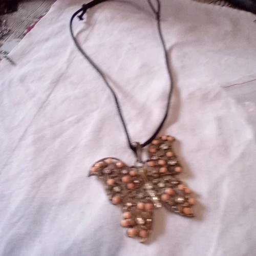 Metal butterfly pendant used on black cord