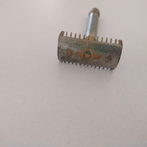 Vintage brass razor used with visible wear and oxidation