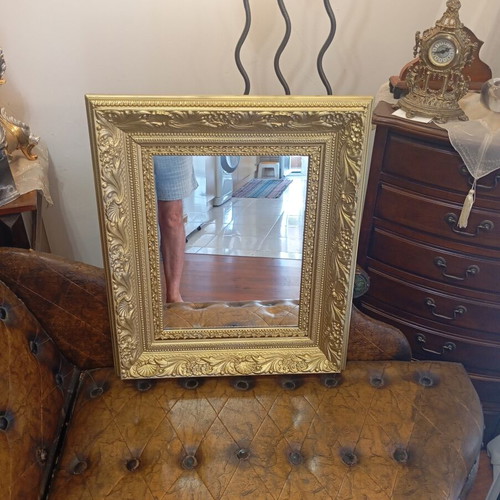 Baroque wall mirror with carved gold frame and embossed motifs