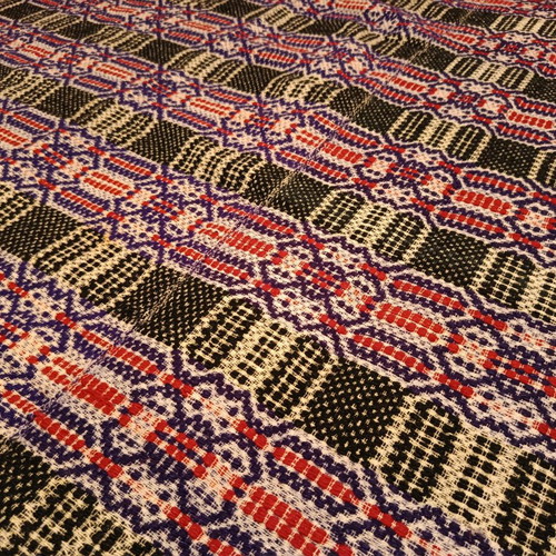 Vintage woolen blanket with red, purple, white and dark green patterns