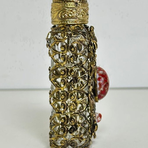Vintage perfume flacon with filigree metalwork and red cabochon