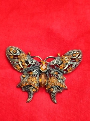 Butterfly brooch like new with filigree and orange rhinestones