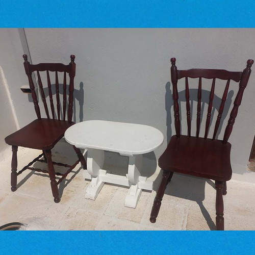 Wooden set with oval white table and 2 traditional dark chairs used for outdoor