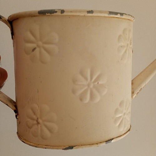 Vintage metal watering can with embossed design