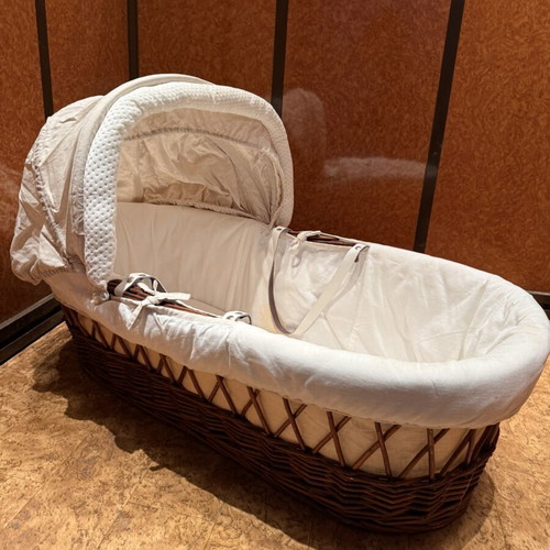Baby bassinet with woven wicker base and hood