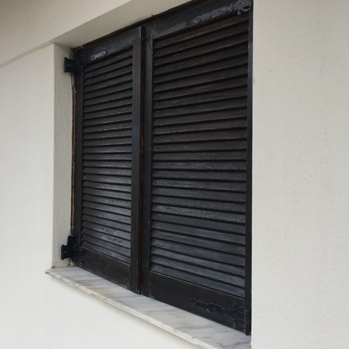 Village-style balcony doors and wooden window used with screen