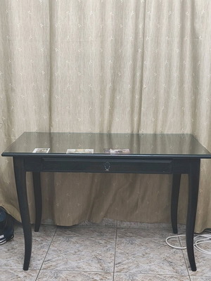 Desk with glass surface used with visible signs of wear