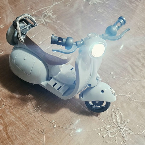 Toy motorcycle for dolls, plays music and moves