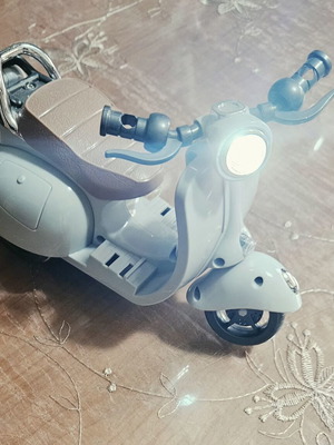 Toy motorcycle for dolls, plays music and moves