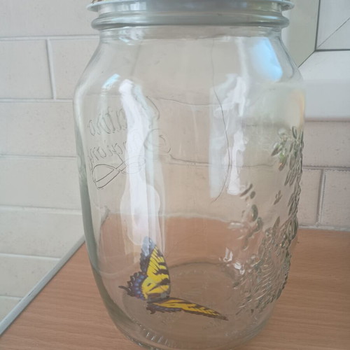 Decorative jar with moving butterfly mechanism