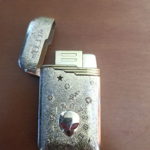 Collectible metal lighter used with zodiac symbols and alien motif