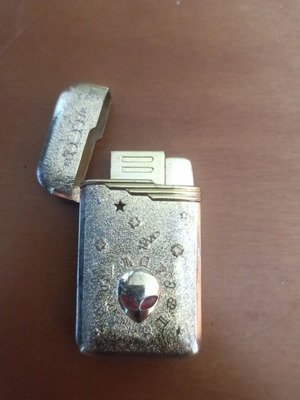 Collectible metal lighter used with zodiac symbols and alien motif