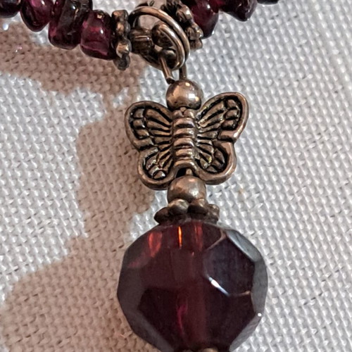 Necklace with purple beads and metallic butterfly and star charms