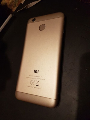 Xiaomi Redmi 4X smartphone with cracked screen, gold