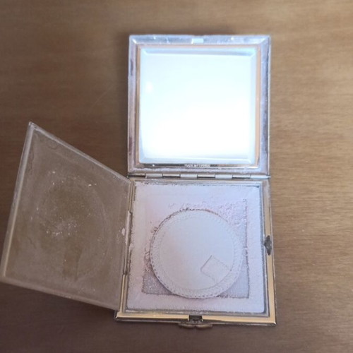 Compact powder with mirror used, black and gold design