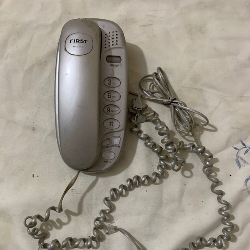 Simple old wired landline phone used, gray