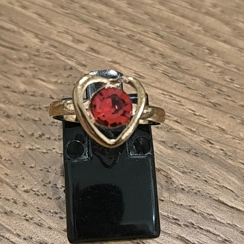 Gold-colored ring with heart and red stone, new
