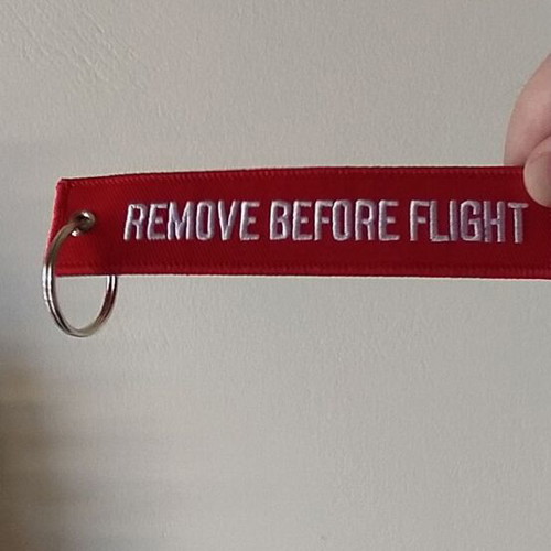 Remove Before Flight keychain new, red