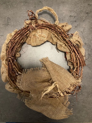 Christmas wreath made of natural materials with knitted handle