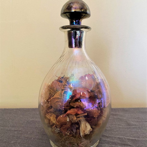Vintage glass bottle with metal stopper and dried flowers used