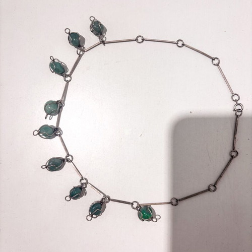 Silver necklace with green precious stones used