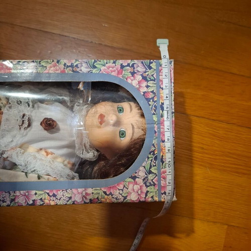Porcelain collectible doll with brown curly hair and vintage dress, new