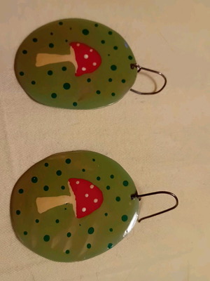 Handmade earrings with mushroom design on green background, silver clasp