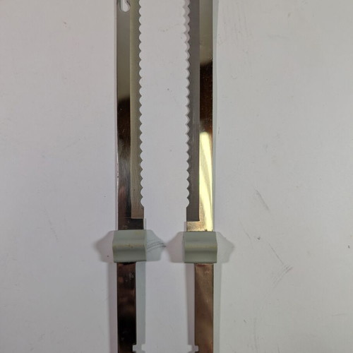 Electric kitchen knife used with 2 double serrated blades and wall mount