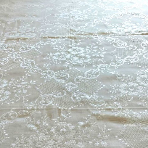 Woven quilt or throw with floral motifs, white