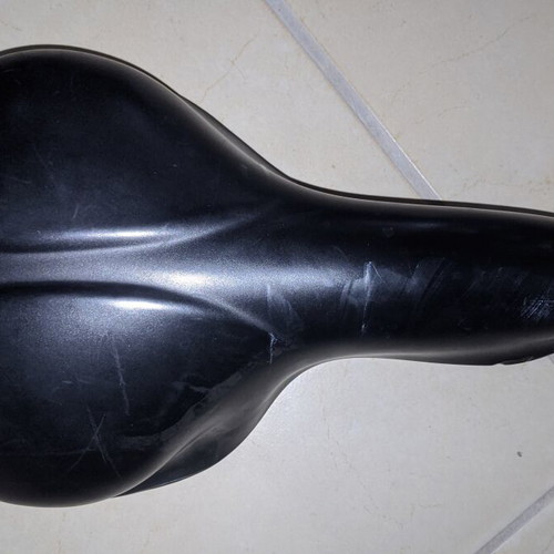Comfortable black bicycle saddle with mounting clamp