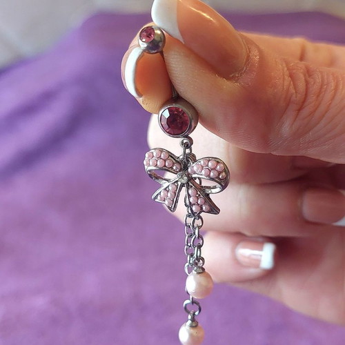 Girlie navel piercing with pink details and bow