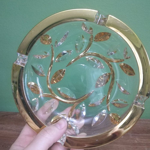 Crystal ashtray used, heavy with embossed gold-plated designs