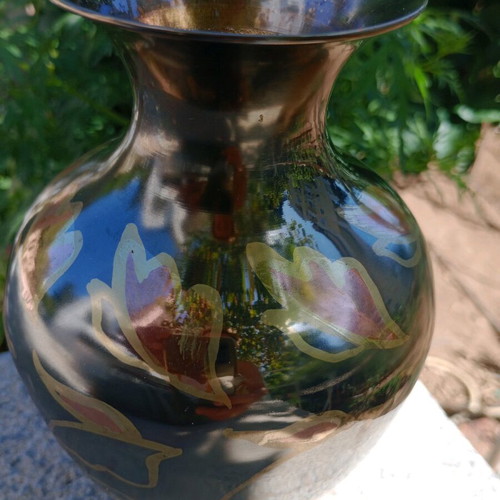 Intricately enameled brass vase with flowers.