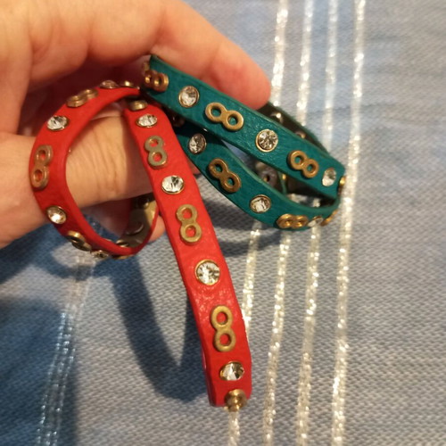 Leather bracelets used, red and green with charms