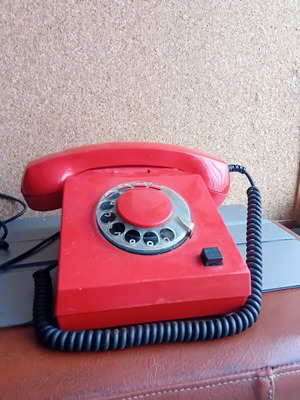 Vintage red telephone with rotary dial used