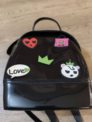 Small black backpack used with decorative patches